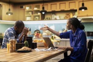 stressed couple struggling to pay rent 2026 sitting at table with bills and calculator