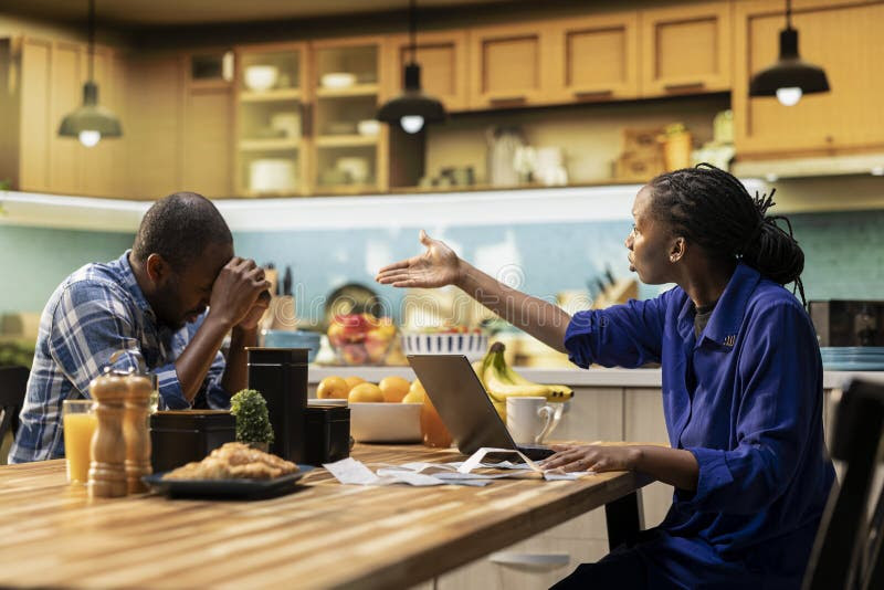 stressed couple struggling to pay rent 2026 sitting at table with bills and calculator